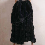 Black bubble bunny fluffy faux fur blanket hanging on wooden ladder, sleek warm throw blanket