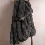 Dark gray bubble bunny fluffy faux fur blanket hanging on wooden ladder, luxury warm throw