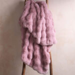 Pink bubble bunny fluffy faux fur blanket draped over wooden ladder, warm plush home decor