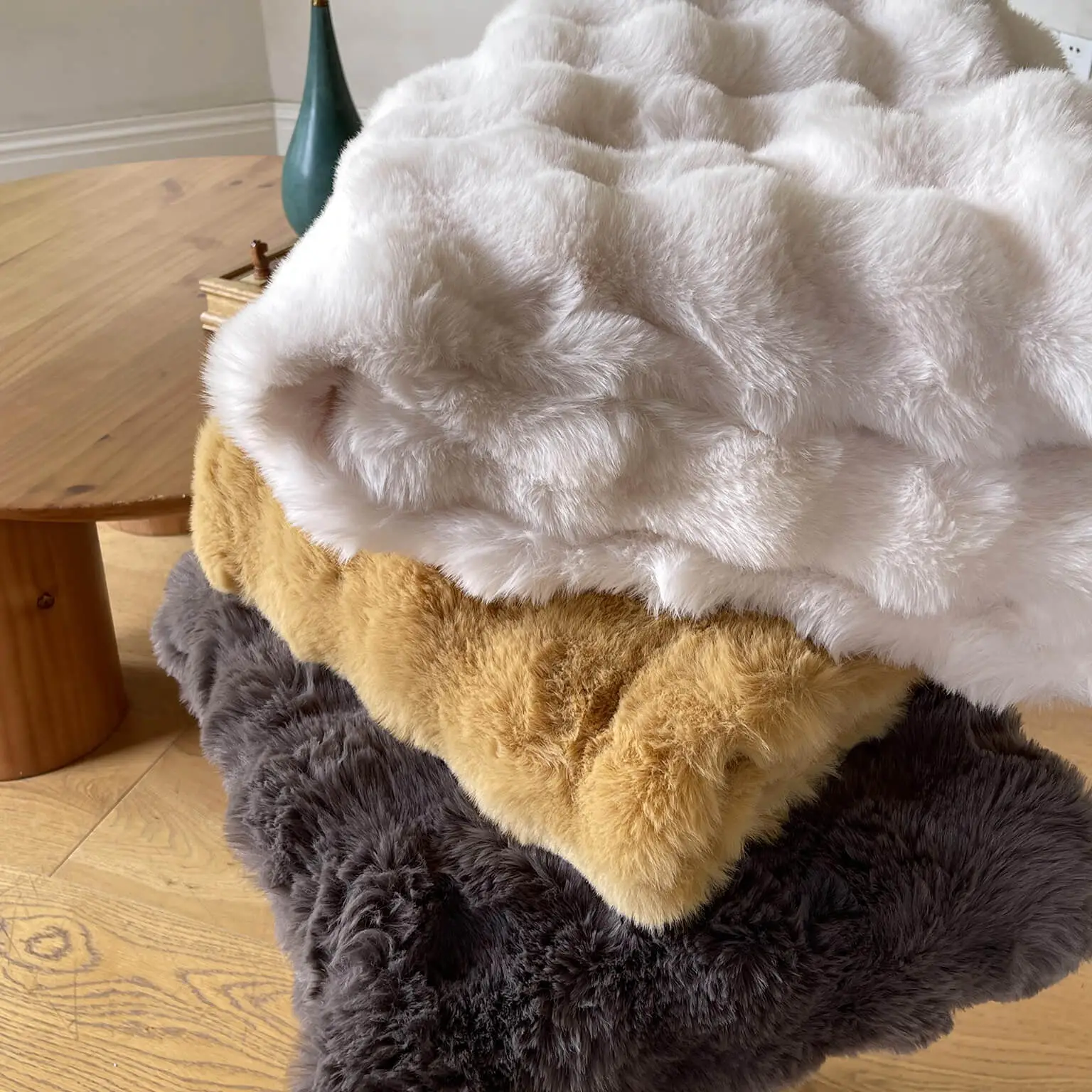 Stacked faux fur blankets showing texture and colors