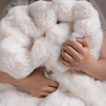 Soft hug scene of cream white bubble bunny faux fur plush blanket for bedroom