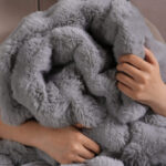Cozy hug scene of light gray bubble bunny fluffy faux fur blanket for bedroom decor