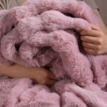 Person hugging soft pink bubble bunny faux fur blanket, fluffy warm plush home bedding