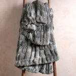 Tie-dye gray dual-sided elastic bunny faux fur blanket draped over wooden ladder, ultra stretch fluffy plush throw