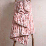 Tie-dye pink dual-sided elastic bunny faux fur blanket hanging on wooden ladder, sweet stretch plush home blanket